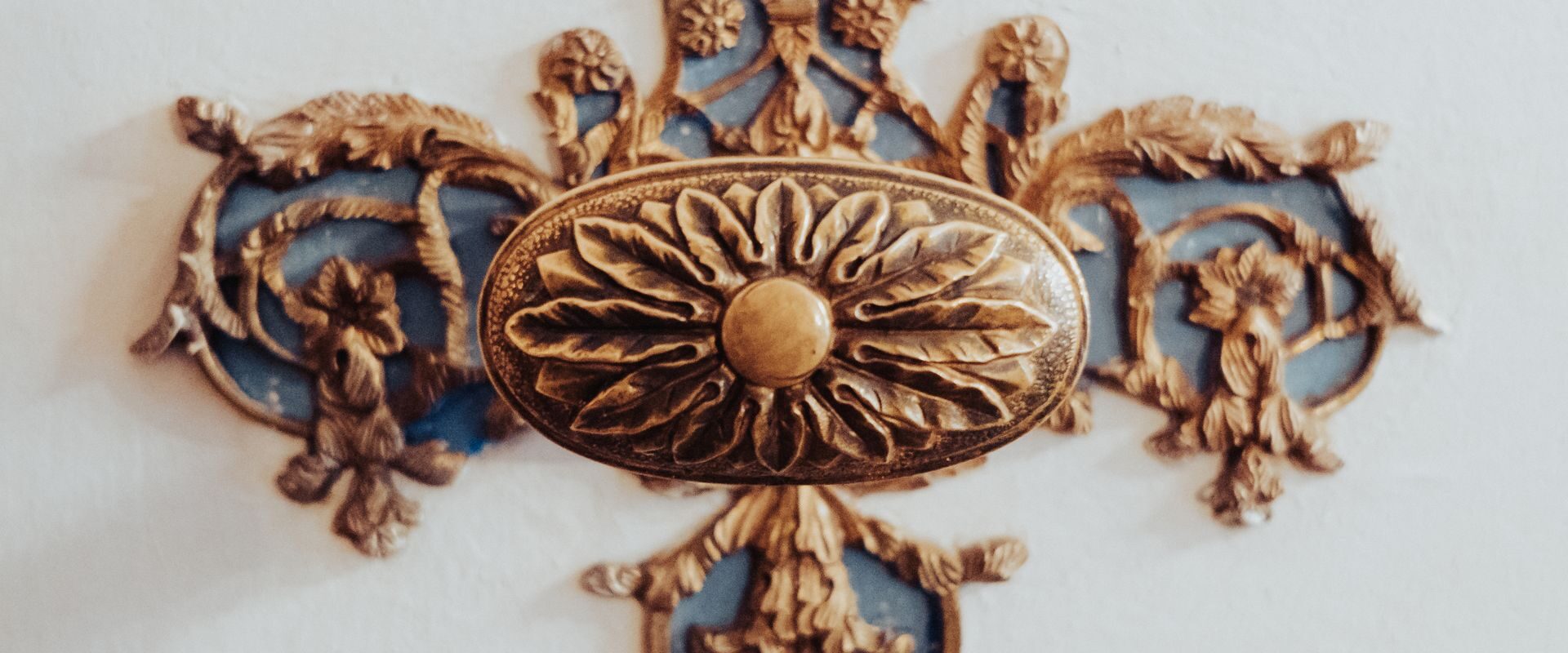 Detalje i messing på en hvid væg