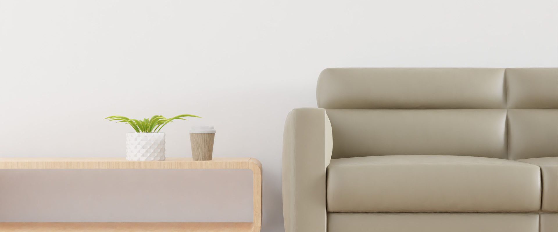 Beige sofa med sofabord, plante og kaffekop